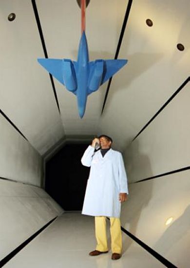 NASA Technician inspecting a wind tunnel model coated with PSP