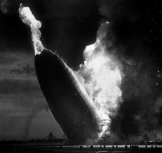Forward half of the Hindenburg towering almost vertically with flames rising